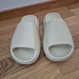 Beige sandaler från Adidas - Säljer ett par stilrena och bekväma beige sandaler från Adidas. Perfekta för sommaren. Följer inte äkta lådan. Köpte den till min mamma men passade tyvärr inte henne.