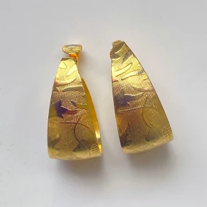 Guldiga örhängen med mönster - Säljer ett par vintage guldiga örhängen med ett snyggt mönster. Perfekta för att ge en touch av glamour till vilken outfit som helst. De är ungefär 5 cm långa och har clips. Okänd metall 