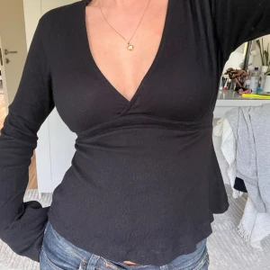Gina Tricot tröja - Skitsnygg långärmad Gina Tricot topp med knytning bak i storleken XS men passar även S💕Toppen är svart och har v-ringning. Har använt enstaka gånger🩷