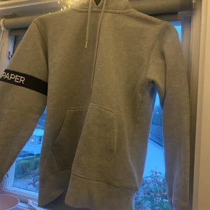 Hoodie  - Grå hoodie som jag fick av en vän. Den är i storlek XS och är från ett märke som heter ”daily paper” det står daily paper på ärmen också.