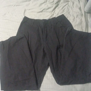 Svarta cargo byxor - Ett par svarta carro byxor med många fickor och snöre både i midja och fot