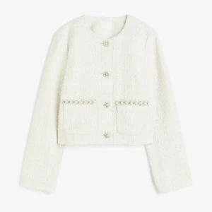 Elegant vit tweedjacka med pärlknappar från H&M.  - Elegant vit tweedjacka med pärlknappar från H&M. Storlek XS, i mycket gott skick. Nypris 349 kr, säljes för 149 kr. Perfekt för en chic och stilren look! Aldrig använd, köpare betalar frakt!
