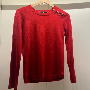 Röd tröja med knappar - Snygg röd tröja med rund halsringning och dekorativa knappar på axeln. Tröjan har långa ärmar och en enkel design som passar perfekt för kyligare dagar. Står 36 men passar som en 34😇