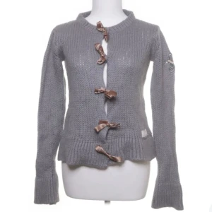 Grå stickad kofta med rosetter - Jättefin grå stickad kofta med rosetter från Odd Molly. Storlek M men passar S också! Bara använd ett fåtal gånger.