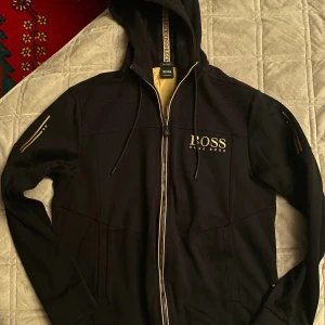 Svart hoodie från Hugo Boss - Snygg svart hoodie från Hugo Boss med dragkedja och huva. 