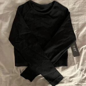 Seamless träningströja  - Helt ny svart cropped seamless träningströja, storleken är M men passar även mig som har Xs,s då materialet är stretchigt, säljer pga att den inte har kommit till användning 