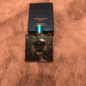 Versace Eros Eau de Toilette - Säljer en flaska Versace Eros Eau de Toilette. Flaskan är i en elegant blå färg med det ikoniska Medusa-huvudet på framsidan. Förpackningen är också blå med guldtext. Perfekt för den som vill ha en fräsch och maskulin doft.