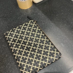 Malene Birger väska - Snygg kuvertväska med ett stilrent svart och vitt mönster. Väskan har en praktisk dragkedja och är perfekt för att bära med sig det viktigaste. Passar både till vardags och festliga tillfällen.  Och det är en clutch alltså inga band