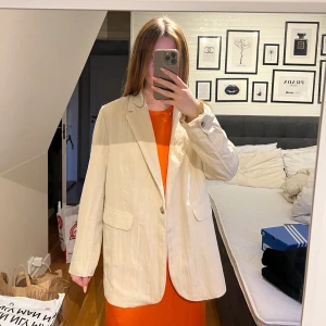 Beige kavaj från Samsøe Samsøe - Helt ny och oanvänd beige kavaj från Samsøe Samsøe. Alla lappar kvar! Så fin, men för stor för mig. Storlek M, nypris 3000, men säljer för typ halva!!! Passa på, först till kvarn🫱🏻‍🫲🏼🥰  Den fina orangea klänningen under är också Samsøe Samsøe och den säljer jag med på min profil!