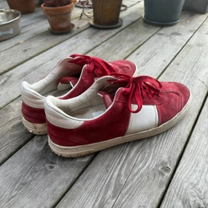 Flycrews - Snygga röda valentino flycrews med vita detaljer och snörning. Skorna har en unik design med nitar på hälen och är tillverkade i mocka och syntetmaterial. (OBS 1 nit saknas på vänster skon och 2 på höger skon) 