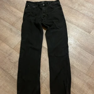 Svarta jeans från Jack & Jones - Snygga svarta jeans från Jack & Jones med klassisk femficksdesign och knappgylf. Perfekta för en stilren look. Priset kan diskuteras!