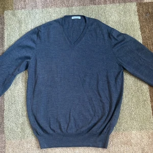 Grå tröja från Gran Sasso - Snygg och stilren grå tröja från Gran Sasso med v-ringning. Perfekt för en elegant och avslappnad look. Tillverkad i Italien med merino ull. 