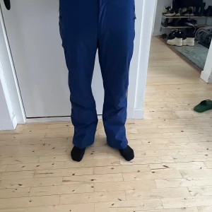 Blå skidbyxor från Schöffel - herr - Säljer ett par Schöffel skidbyxor i storlek L. Byxorna är i en snygg blå färg med slitstarkt material, perfekt för skidåkning eller andra utomhusaktiviteter. Försedda med praktiska fickor.  Personen på bilderna är 184 cm lång.  Skick: bra skick.  Nypris: 2 500 SEK