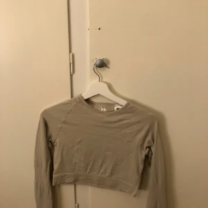 Beige croppad tröja från Lager 157 - Säljer en beige croppad tröja från Lager 157. Tröjan har långa ärmar och en enkel design, perfekt för en avslappnad stil. Passar bra till jeans eller kjol.