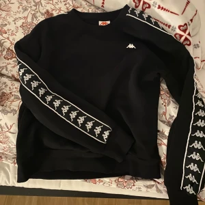 Svart sweatshirt från Kappa - Säljer en sweatshirt från kappa i strl M, mycket bra skick nästan som ny skick! Använd ca 3 gånger! Säljer den för 250kr + frakt!