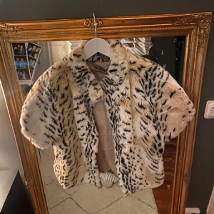 Mönstrad pälsjacka/bolero från Giallolimone - Snygg och trendig pälsjacka/bolero från Giallolimone med ett djurinspirerat mönster i beige och svart. Jackan har en kortare passform och är perfekt för att ge en lyxig touch till din outfit❤️ strl står ej men skulle säga ca S