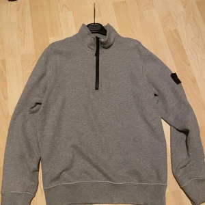 Grå tröja från Stone Island - Säljer min gråa stone island half zip då den inte används. Den är äkta med qr kod som kan verifiera det. Kan även bytas mot snowboarding kläder, skidglasögon mm