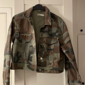 Camouflage jeansjacka - Snygg och trendig camouflage jeansjacka från Zara. Jackan har en croppad passform med knappar framtill och två bröstfickor. Perfekt för en cool och avslappnad stil.