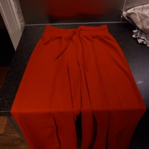 Byxor - Snygga och bekväma röda byxor med elastisk midja och snörning. Perfekta för en avslappnad stil. Finns inga tecken på användning. Står att dem är L men skulle mer säga att dem är M. 