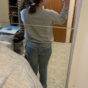 Blåa bootcut jeans - Säljer dessa jeans i storlek 32 då dom inte kommer till andvändning längre. Tyvärr har dom två hål vid sidorna men det kan enkelt sys upp! Dom är i från ett mårke jag inte känner igen då ja fick dom av en familjemedlem.