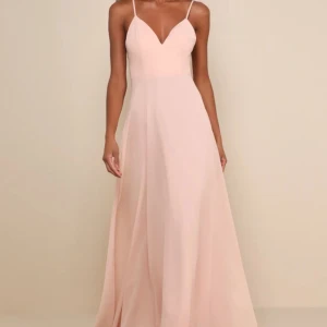 Rosa balklänning  - Säljer min balklänning som jag har använt en gång, endast på balen i 9:an. Klänning med smala axelband och v-ringad fram. Baksidan har vackra spetsdetaljer och knappar längs ryggen. Skriv för egna bilder🥰