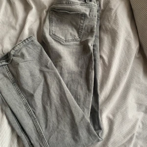 Grå jeansbyxor från Gina Tricot - Snygga lågmidjade gråa jeans från Gina Tricot i storlek 146. Byxorna har 3 knappar framtill. Säljer för dom blivit försmå men har alltid suttit skit bra. Nackdelen är att dom har blivit pyttelite slitna längst ner i ena benet men inget man tänker på💕