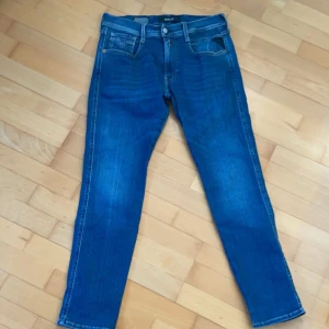 Replay Anbass  - Säljer ett par riktigt feta blå jeans från Replay i modellen Anbass. Jeansen kostar ca 1709 nypris men säljer endast för 499. Passar perfekt när som helst på dygnet oavsett om du ska till skolan eller om du ska gå ut. Vid frågor eller funderingar är det bara att höra av sig. St:W31/30.