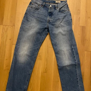 Blå Levis 501 jeans 90s - Klassiska blå Levis 501 90s jeans med en straight passform. De har en knappgylf och femficksdesign. Perfekta för en avslappnad stil.
