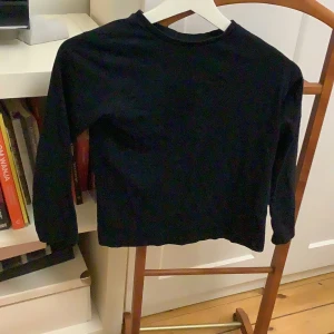 Svart långärmad tröja - Säljer en enkel och stilren svart långärmad tröja. Perfekt för en minimalistisk look och kan enkelt matchas med olika outfits. Tröjan är gjord i ett mjukt material som känns skönt mot huden.