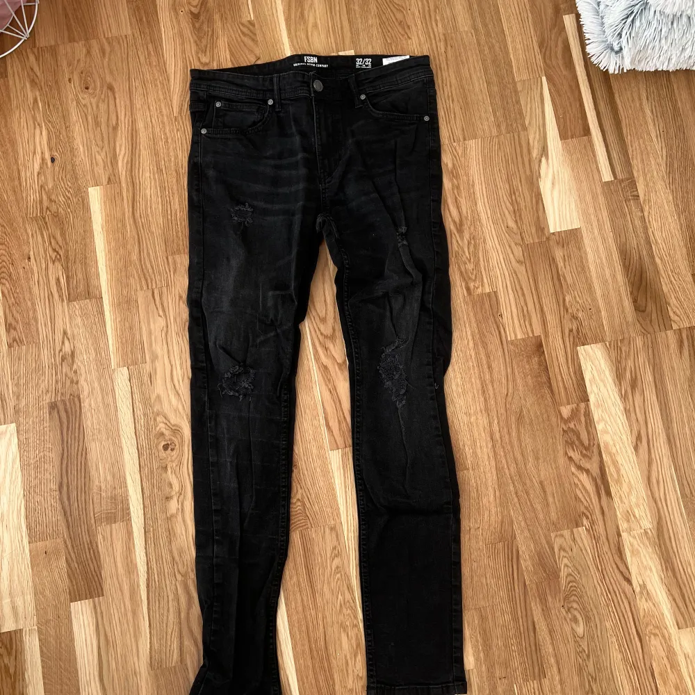 Säljer ett par svarta jeans från new yourker i storlek 32. De har en slim passform och coola slitningar på benen som ger en edgy look. Perfekta för både vardag och fest! 🖤. Jeans & Byxor.