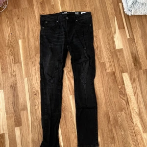 Svarta jeans med slitningar - Säljer ett par svarta jeans från new yourker i storlek 32. De har en slim passform och coola slitningar på benen som ger en edgy look. Perfekta för både vardag och fest! 🖤