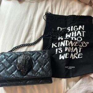 Kurt Geiger väska - Säljer min coola väska från kurt geiger då den inte kommer till användning. Kollar man noga så har några få små stenar lossnat från fågeln men inget man märker om man inte kollar noga💞