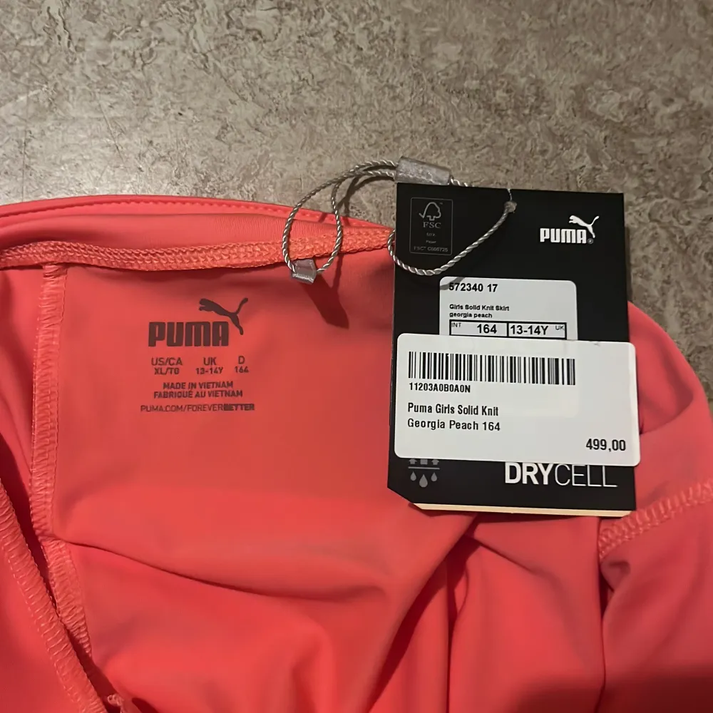 Säljer en superfin korallfärgad golfkjol från Puma i storlek 164. Kjolen är gjord i ett mjukt och stretchigt material. Perfekt för en golf tur. Den har en enkel design med en ficka på baksidan. . Kjolar.