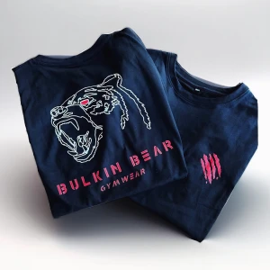 Svart t-shirt från Bulkin Bear - Säljer en svart t-shirt från Bulkin Bear Gymwear. Den har ett coolt tryck av en björn i vitt och rött på framsidan och texten 'Bulkin Bear Gymwear' i rött. Perfekt för gymmet eller en avslappnad dag.