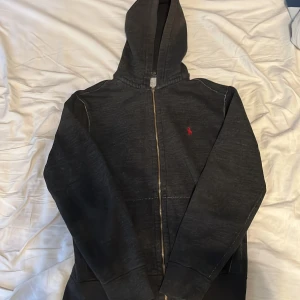 Polo zip hoodie - Snygg polo hoodie. Använd sparsamt men har några defekter som kedjan och lite små slitningar på armen, men inget man märker. Varav priset. Pris ej hugget i sten och kan diskuteras. Hoodien har ett mjukt och skönt material inuti som kan ses på bild.