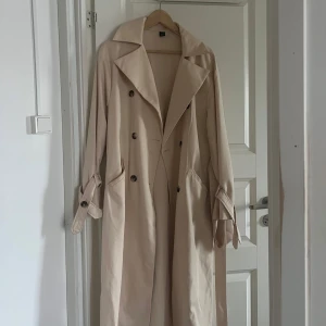 Trenchcoat - Beige trenchcoat i storlek L, inga skador eller liknande. Kommer inte till användning!