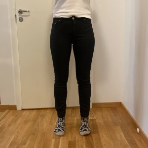 Svarta skinny jeans från Stockholm  - Säljer ett par svarta skinny jeans från Stockholm . De är högmidjade och har en snygg, tight passform som sitter perfekt. Jeansen är i bra skick och passar till både vardag och fest. Perfekta för höst och vinter!