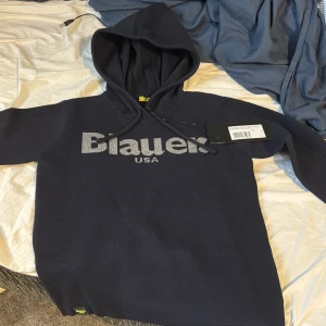 Blauer hoodie - Fett skön och snygg hoodie från Blauer. Den är helt ny från affären här alla tags på. Tänker skicka tillbaka den men vill se om jag kan få lite mer pengar för den pga man inte kan köpa den i Sverige. Passar typ 150cm. Snygg och bra hood och bra känsl