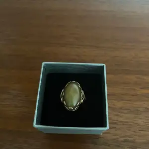 Otroligt vacker ring i äkta guld 18k, med en olivgrön cabochonslipad agat. Stämpel finns.  Innerdiametern är ca 17 mm.