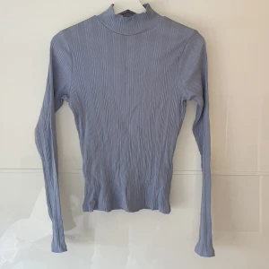Långarmad tröja Gina Tricot - En ljusblå långärmad tröja från Gina Tricot i storleken M, väldigt stretchigt material och har ditaljer som slits i armen!!