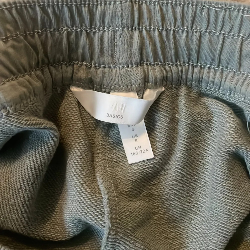 Säljer ett par bekväma grå shorts från H&M i storlek S. De har en elastisk midja med snörning för perfekt passform. Perfekta för en avslappnad dag hemma eller en promenad i parken. 🩶. Shorts.