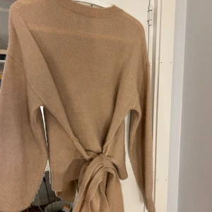 Stickad tröja - Jätte fin beige stickad tröja med knuten rosett i ryggen ifrån other storys🎀💝