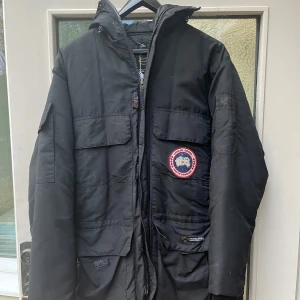 Canada Goose vinterjacka  - Dragkedjan är sönder och går inte att öppna helt och hållet, går däremot att lag utan några problem. Jackan är i M men passar mer som L. I och med att blixtlåset är sönder säljer jag jackan till ett väldigt billigt pris!