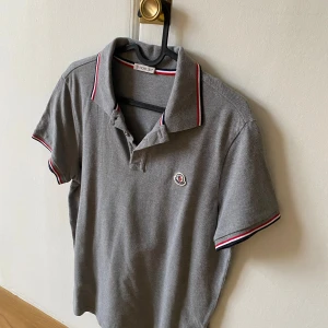 Moncler piké - Grå Moncler piké, storlek S, skick, 9/10. Använd runt 10 gånger. Bara ligger i garderoben så vid snabb affär kan den säljas billigare.