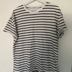 Filippa K T-shirt - Säljer en randig Filippa K t-shirt. Storlek M men herr men sitter som dam M och har kvinnligt skurna armändar.