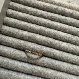 Elegant guld ring med stenar - Säljer en superfin och elegant ring i guld med gnistrande stenar runt om. Perfekt för att ge en touch av glamour till vilken outfit som helst. Passar både till vardags och festliga tillfällen. En tidlös accessoar som aldrig går ur stil!