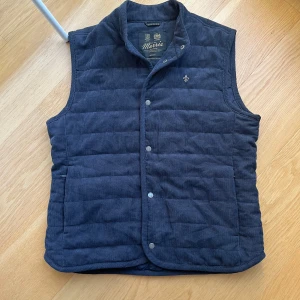 Morris Väst i Manchester tyg - Hej! Säljer nu min riktigt snygga väst från morris i Manchester tyg. Skicket är 9/10 mycket sparsamt använd och inga tecken på användning. Färgen är mörk blå även om den ser lite svart ut i ljuset på vissa bilder. Skriv vid minsta fundering!