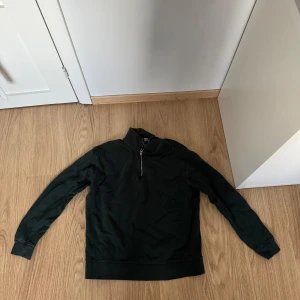 Grön tröja med dragkedja från Zara - Säljer en stilren grön tröja från Zara i storlek M. Tröjan har en praktisk dragkedja vid halsen och är perfekt för både vardag och fest. Den är långärmad och gjord i ett mjukt material som känns skönt mot huden. Passar perfekt till höst och vinter!