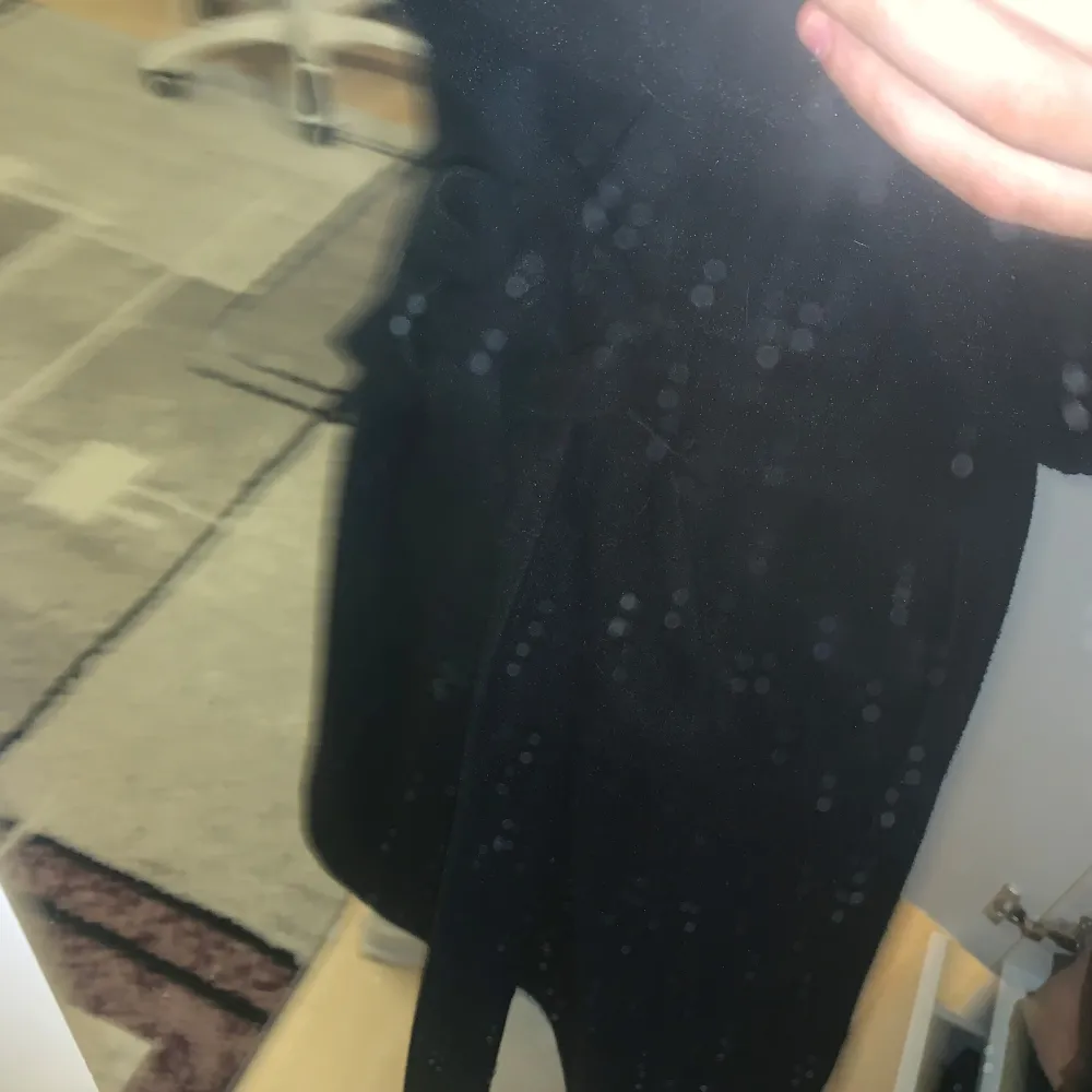 Säljer en stilren svart kappa i normal passform. Perfekt för både vardag och fest. Den har långa ärmar och en enkel design som gör den lätt att matcha med olika outfits. Ett måste i garderoben för en klassisk look! Har knutit där bak då det är därför den sitter så fint!. Takit.