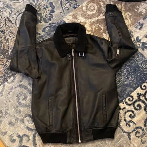 Läderjacka  - Supersnygg svart läderjacka med en dragkedje detalj på ena armen 